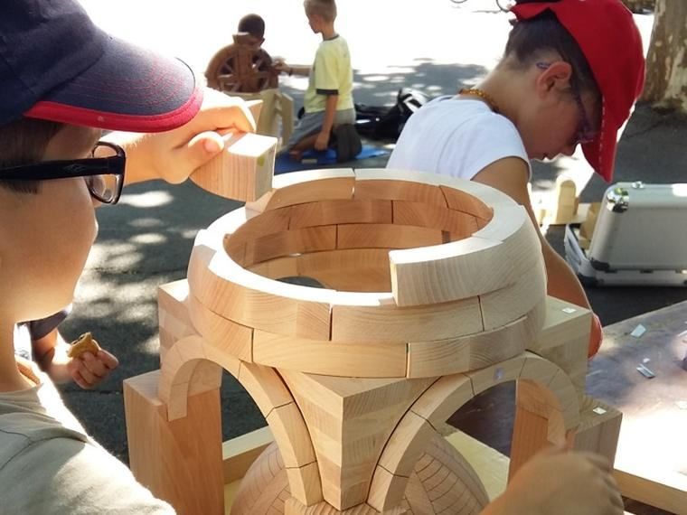 En atelier, un enfant assemble la maquette de la coupole sur pendentifs
